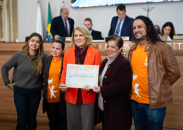 Equipe da Associação Fênix recebendo prêmio da vereadora Meri Martins